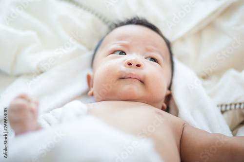 Infant baby boy lying on white blanket