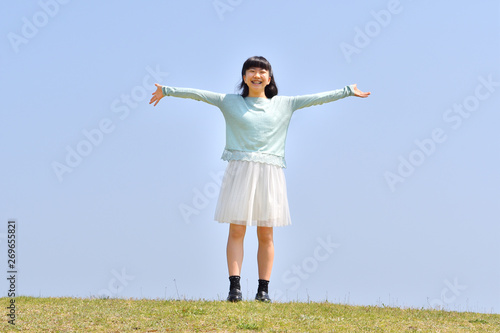 青空で手を広げる女の子