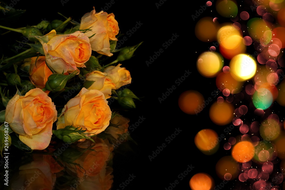 beautiful yellow roses with buds and green leaves on a shiny background