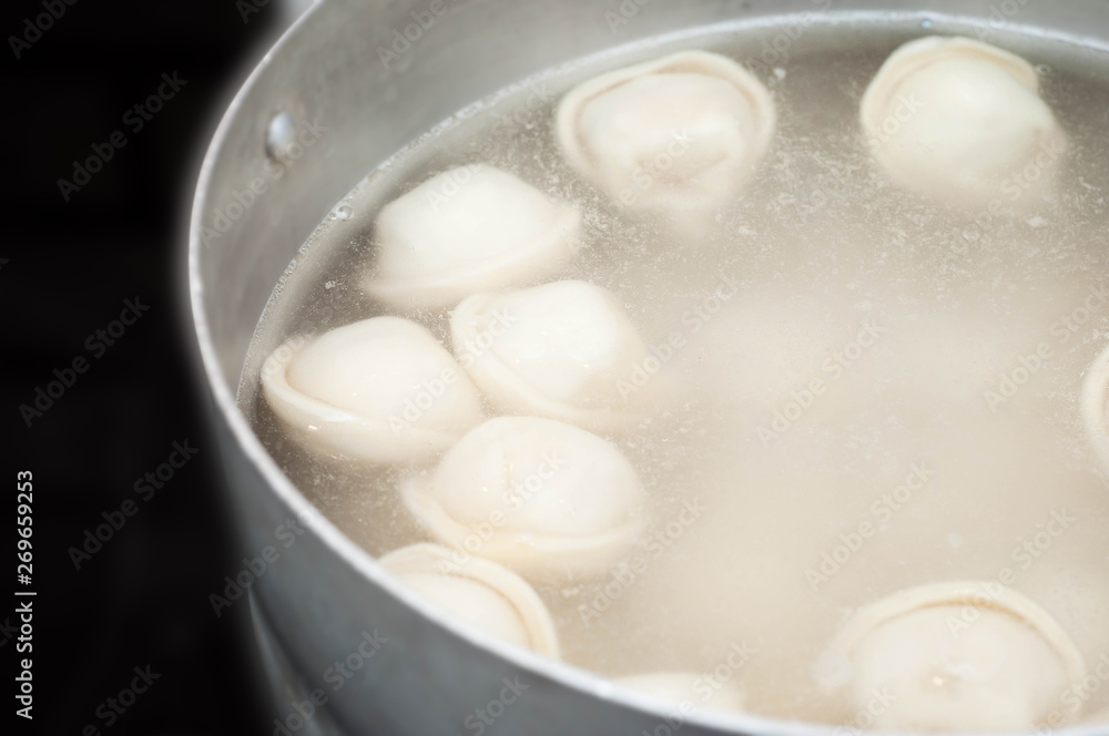 Saucepan with dumplings in hot water coming to a boil a second before filling the stomach semi-finished Saucepan with dumplings in hot water coming to a boil a second before filling the stomach semi-finished