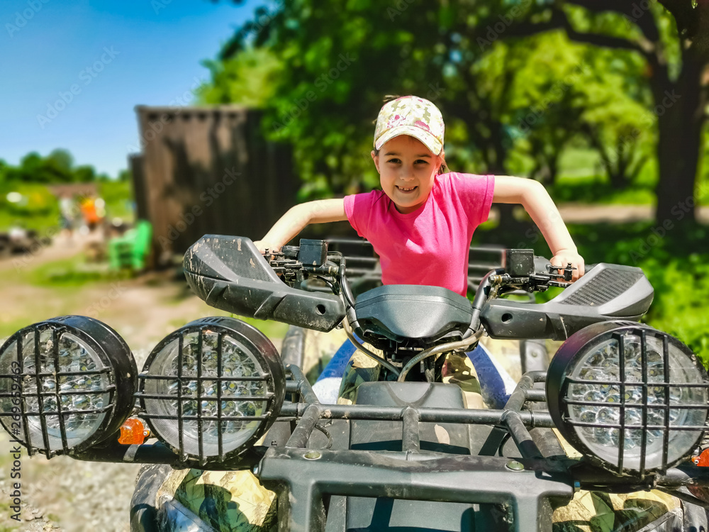 Little girl riding ATV quad bike in race track Little girl riding ATV quad bike in race track