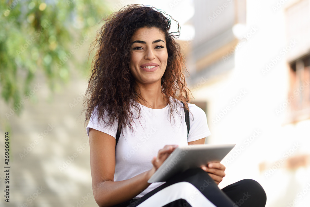 Obraz premium Smiling African woman using digital tablet outdoors