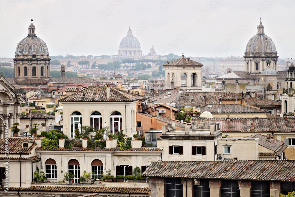 Panorama of Rome's rooftops with three church domes. Photograph