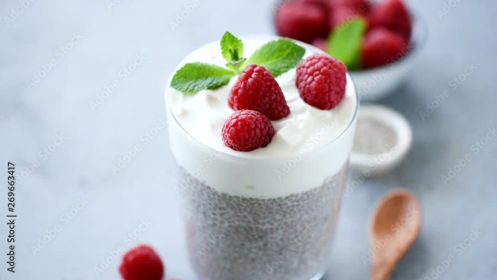 Chia pudding with greek yogurt and berries in glass on concrete table background. Healthy eating, lifestyle, vegetarian diet food concept Chia pudding with greek yogurt and berries in glass on concrete table background. Healthy eating, lifestyle, vegetarian diet food concept