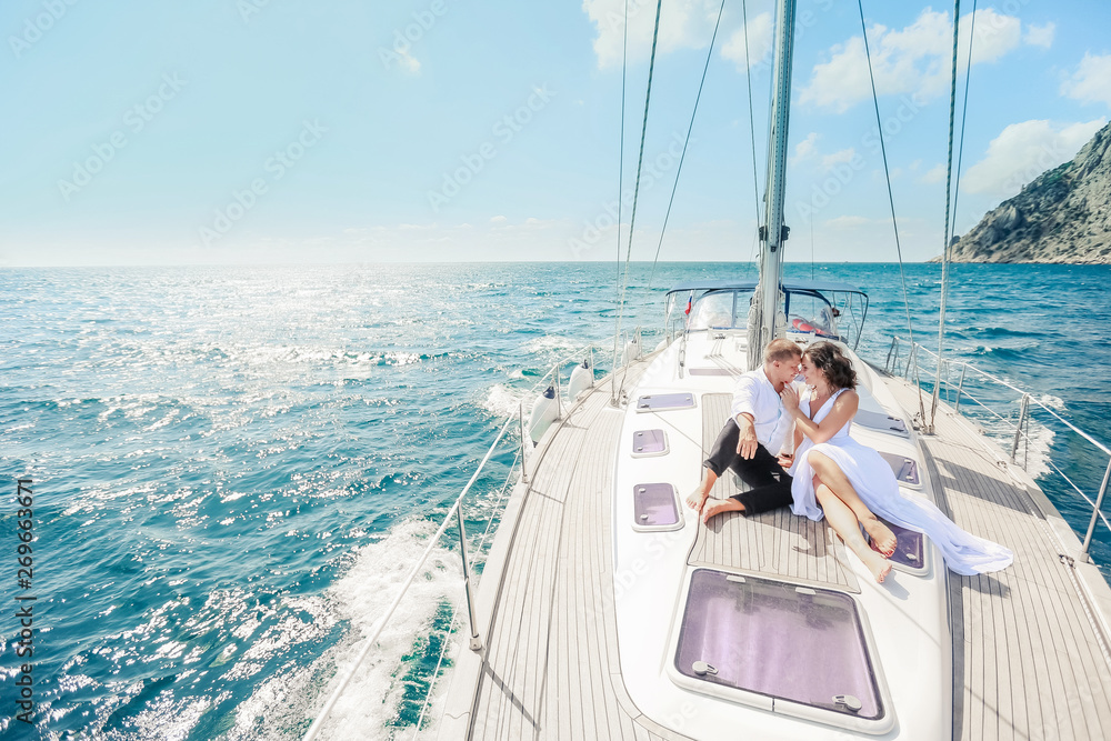 Young Couple Relaxing on a Yacht. Happy wealthy man and a woman by private boat have sea trip. Young Couple Relaxing on a Yacht. Happy wealthy man and a woman by private boat have sea trip.
