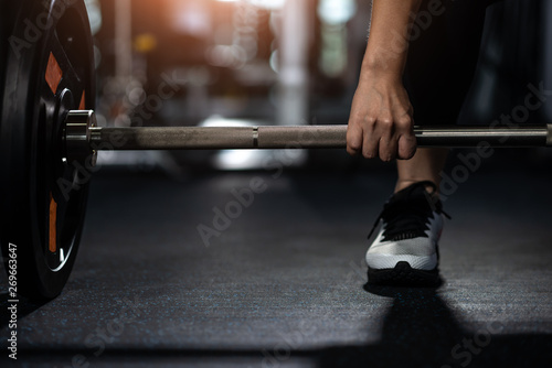 Closeup of young woman holding barbell