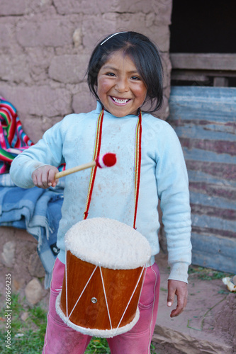 Little native american girl playing traditional sikuri drum. photo