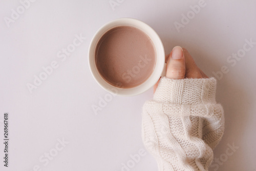 Top view of woman hand holding cup of coffee on white background. 