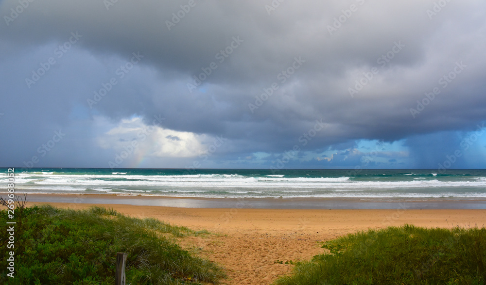 Dramatic sky with large clouds over Arrawarra beach (North Coast, NSW, Australia). Gushing sea on a cloudy day. Horizontal view of dramatic overcast sky and sea. Fifty shades of blue and grey. Dramatic sky with large clouds over Arrawarra beach (North Coast, NSW, Australia). Gushing sea on a cloudy day. Horizontal view of dramatic overcast sky and sea. Fifty shades of blue and grey.