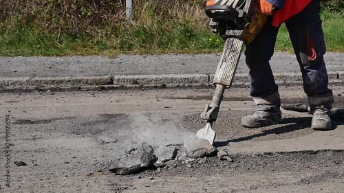 ouvrier de la voirie en action avec un marteau-piqueur