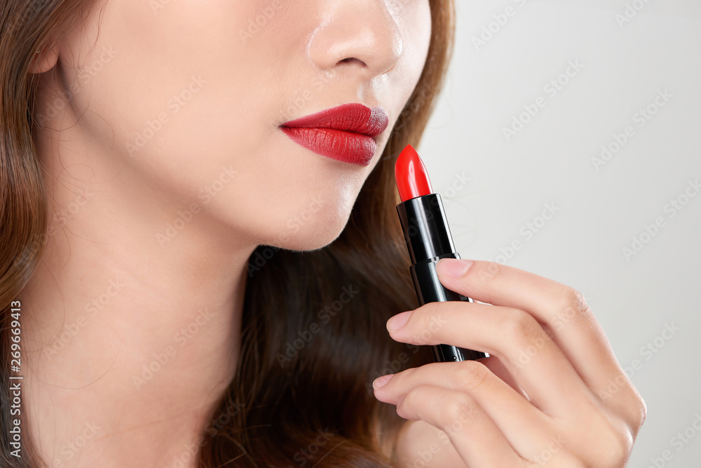 Attractive woman applying red lipstick