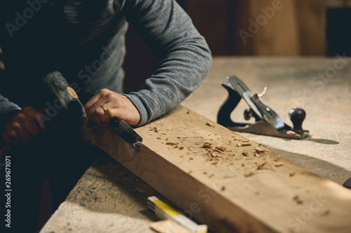 Carpenter at work on wood table with tools