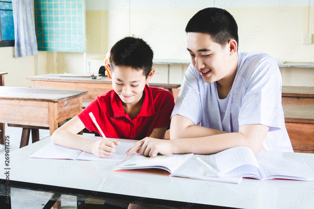 Boys learning and doing homework in the classroom together Boys learning and doing homework in the classroom together