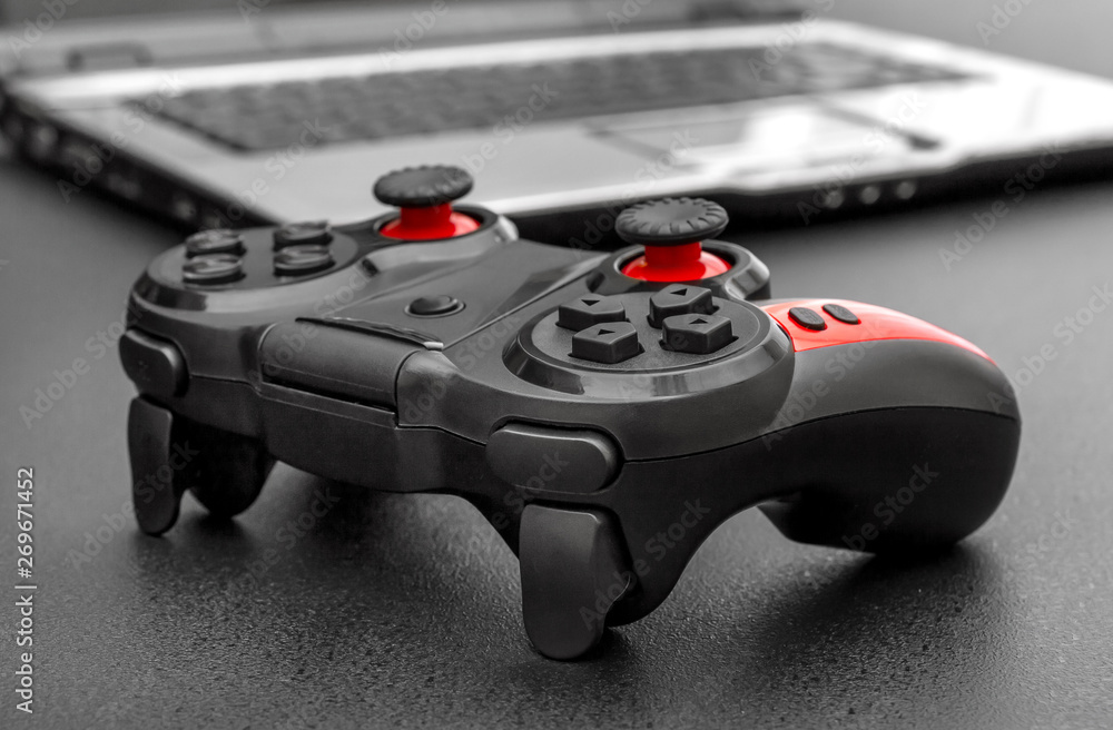 Gamepad with laptop on black background. Gamepad with laptop on black background.