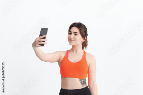 Young brunette woman making selfie during workout. Sport activity for weight loss.