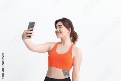 Young brunette woman making selfie during workout. Sport activity for weight loss.