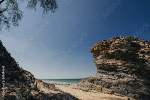 Beautiful tropical island beach scenery with palm trees,nature rock formation and blue sky background.