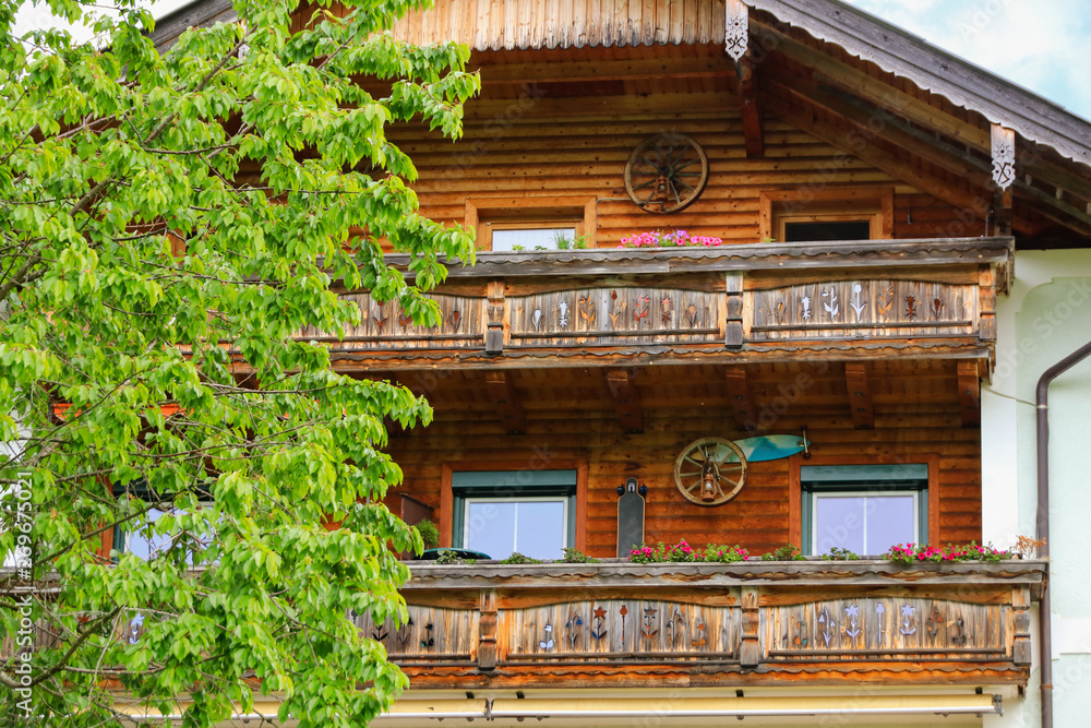 Popular traditional architecture, flowery wooden house with balcony, Holiday destination Fuschl am See - Salzkammergut, Austria