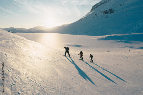 Cuadro en lienzo three hikers with shadows are skitouring in norway landscape in sunset