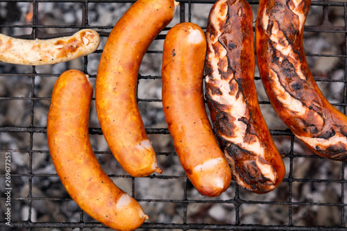 the process of cooking sausages or sausages on the grill
