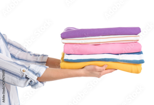 Young woman holding clean towels on white background, closeup. Laundry day