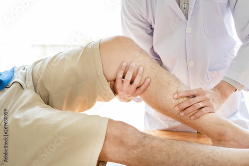 physiotherapist doctor rehabilitation consulting physiotherapy giving exercising leg treatment with patient in physio clinic or hospital
