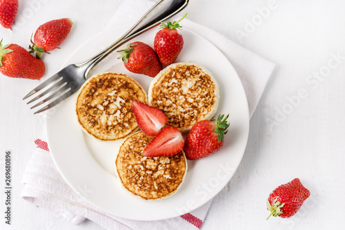ThreeTasty Homemade Cottage Cheese Pancakes with Strawberries on White Plate Tasty Healthy Diey Breakfast Breakfast Concept Top View Flat Lay Copy Space