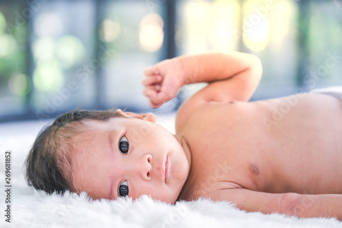 2-month-old babies lie on the white cloth and the morning sun shines.