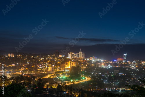 Kigali city centre skyline and surrounding areas lit up at night under a dark blue sky