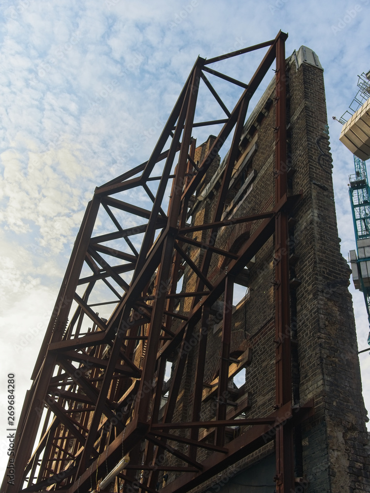 View of a historical building facade conservation / rebuilding. Scaffolding supporting the only renaming facade.