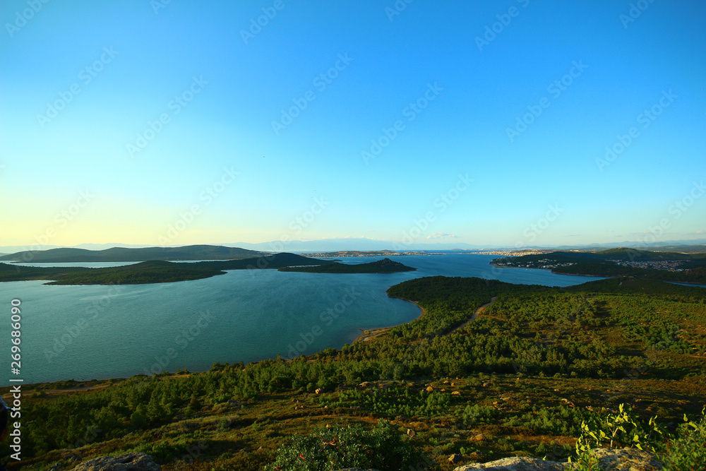 Seascape and islands. Green herbs. Photographed from the hill during sunset. Blue sky.
