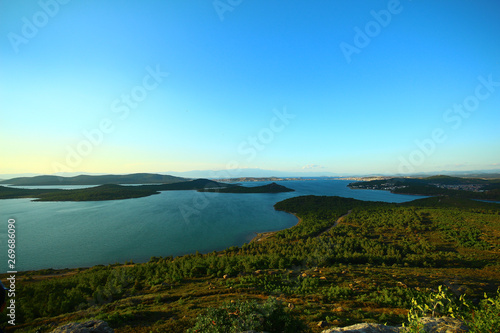 Seascape and islands. Green herbs. Photographed from the hill during sunset. Blue sky.
