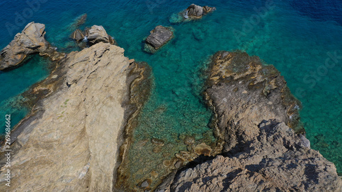 Aerial drone photo of iconic deep turquoise beach of Latinaki with crystal clear sea and rocky sea shore forming small caves  Folegandros island  Cyclades  Greece