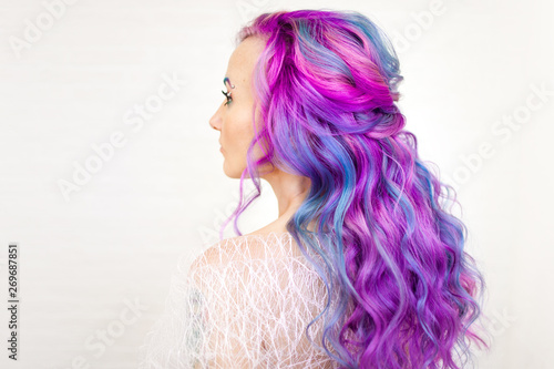 Stylish trendy hairstyle of curly blonde hair. Fashionable hair coloring,