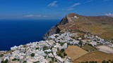 Aerial drone photo of picturesque main village (chora) of Folegandros island featuring uphill church of Panagia (Virgin Mary) built on top of steep hill overlooking the Aegean sea, Cyclades, Greece