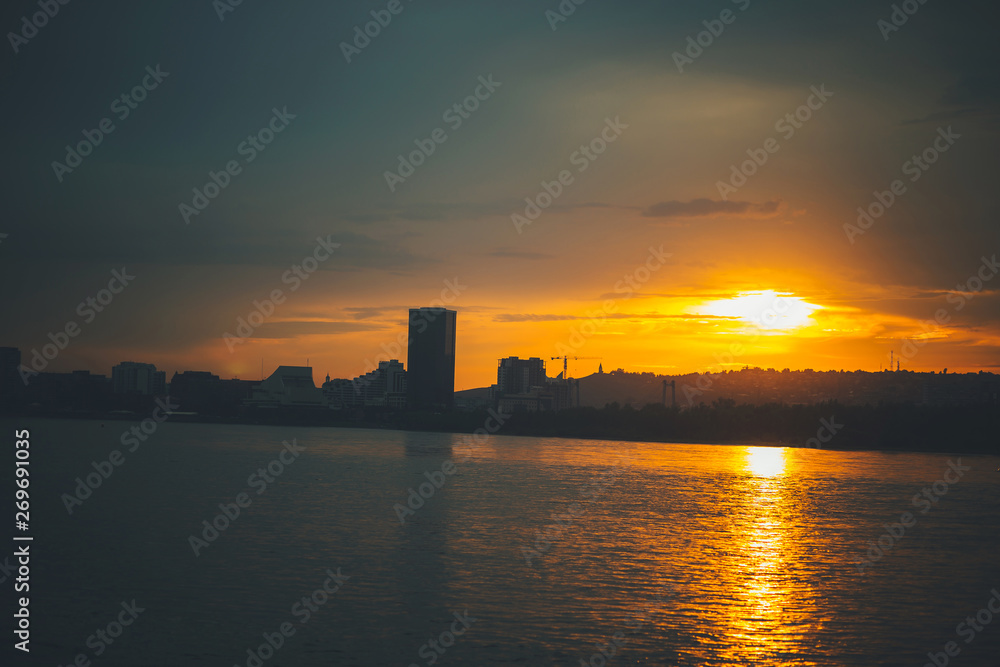 Silhouette of the night city on the river at sunset. Evening Krasnoyarsk