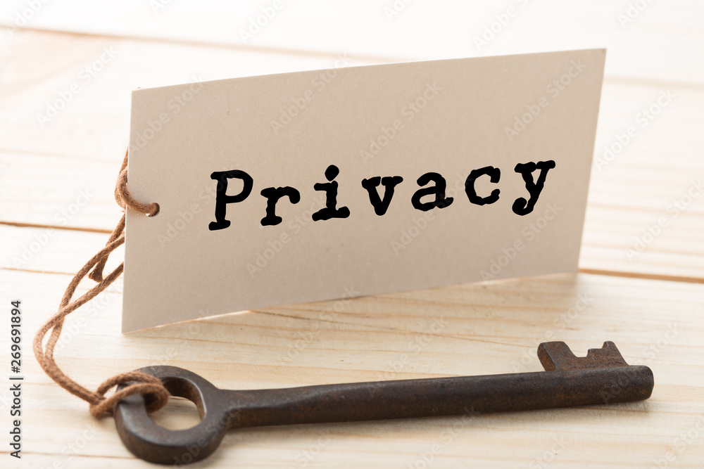 privacy concept - little house and key with inscription on the wooden desk privacy concept - little house and key with inscription on the wooden desk