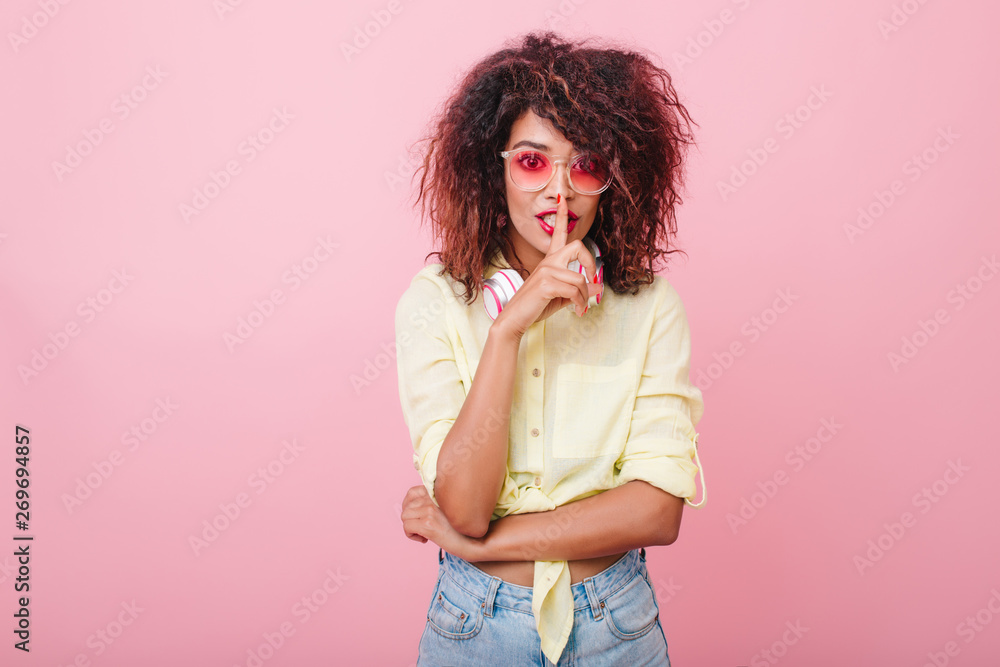 Adorable girl in pink cotton shirt telling secret. Sensual slim woman in casual summer outfit touching red lips with finger and looking with interest. Adorable girl in pink cotton shirt telling secret. Sensual slim woman in casual summer outfit touching red lips with finger and looking with interest.