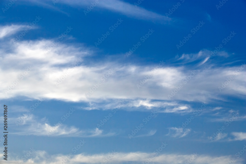 White sparse clouds over blue sky