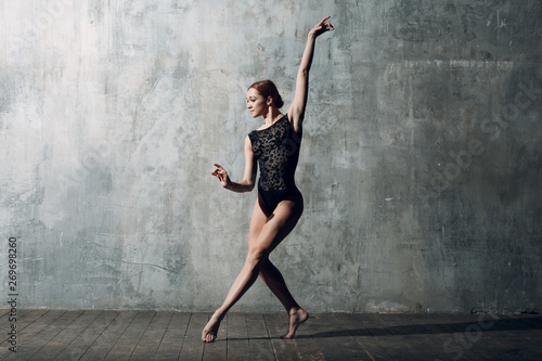 Ballerina female. Young beautiful woman ballet dancer, dressed in professional outfit, pointe shoes and black body ballet.