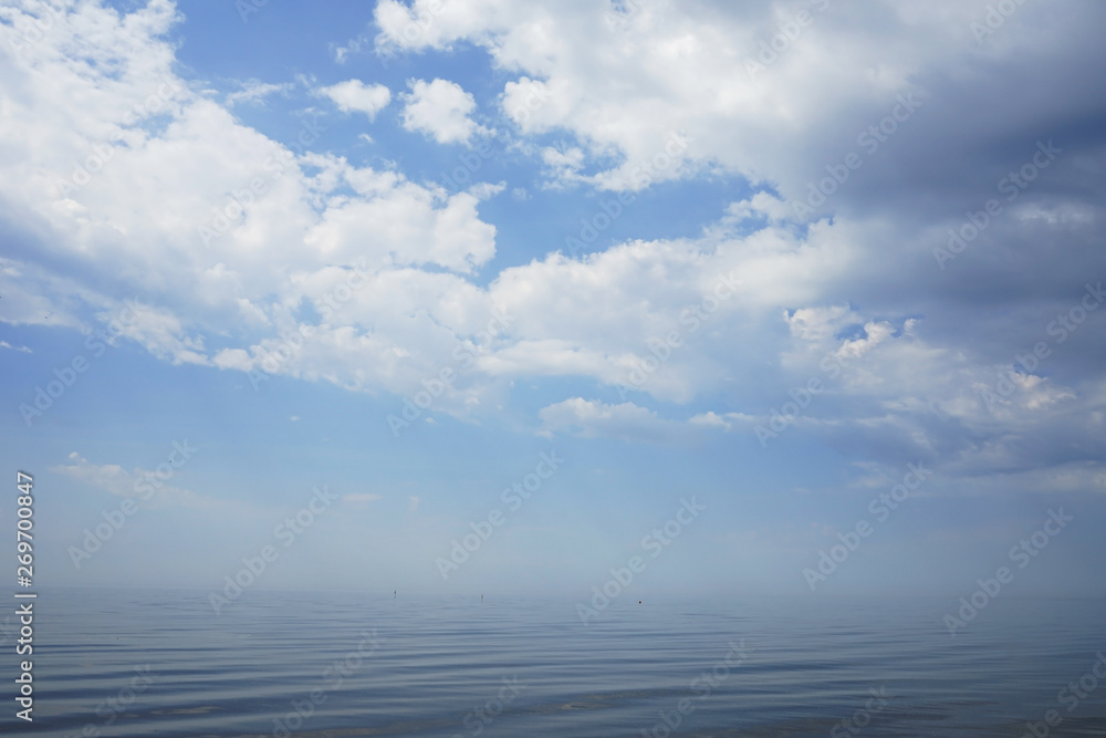 calm sea with a haze on a blue cloudy sky calm sea with a haze on a blue cloudy sky
