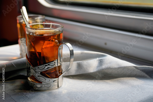 Glass with tea in train railway carriage photo
