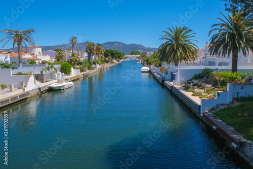 Amazing view on marine canal with boats and houses. Resort town landscape with palm trees  little Spanish Venice  Empuriabrava. Rich lifestyle  Summer time.