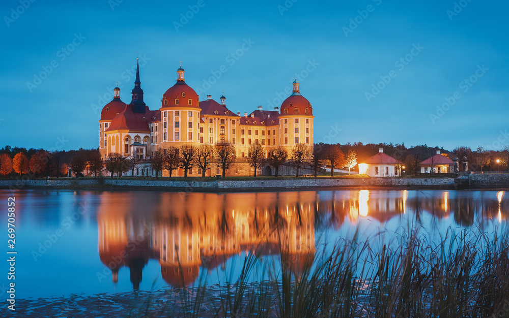 Fototapeta premium Moritzburg Castle near Dresden, in the night illumination reflected in the water. Wonderful autumn sunrise in Saxony, Dresden, Germany, Europe. Popular Places for photographers. Creative image