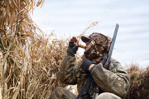 Konstfotografi hunter sits in the shelter and lures the ducks