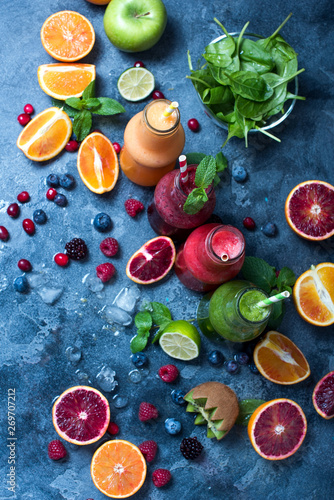 Colorful detox smoothie in bottles, summer diet fresh drink, red, green, yellow smoothie with berries and fruits