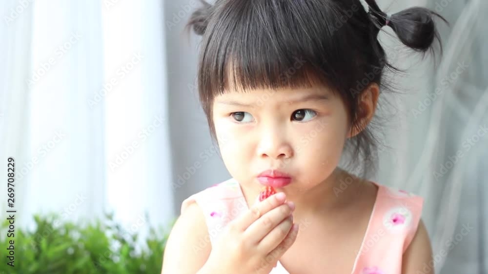 children eating a very tasty strawberry . children eating a very tasty strawberry .