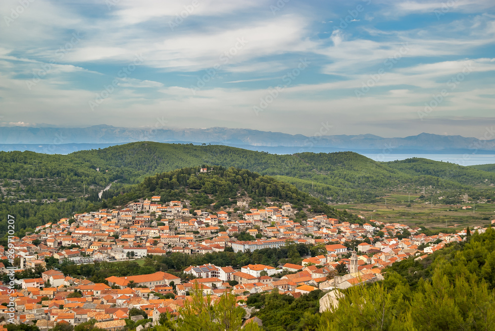 Beautiful panoramic view of the city of Blato, green forest hills, blue waters of the Adriatic Sea and high mountains in the background, Korcula Island, Croatia.