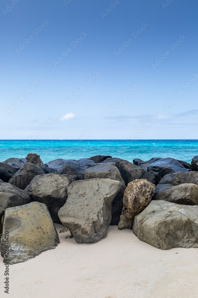 Looking out to sea over a barrier of large rocks, on the Caribbean island of Barbados Looking out to sea over a barrier of large rocks, on the Caribbean island of Barbados