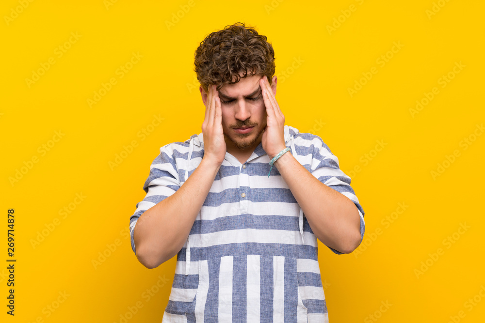 Fototapeta premium Blonde man over yellow wall unhappy and frustrated with something
